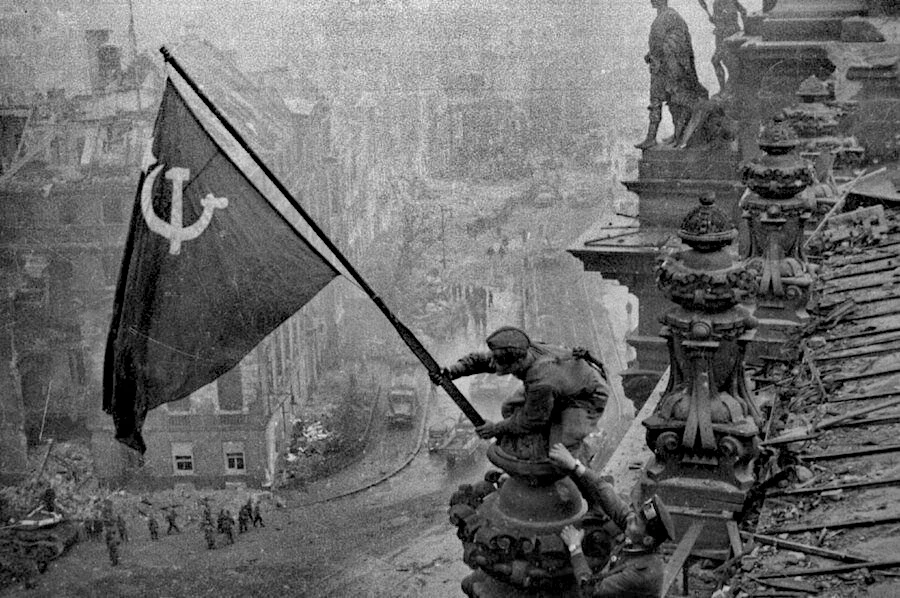 Le drapeau rouge de la Victoire et les fleurs des petits moscovites Seconde Guerre mondiale Russie Union européenne 